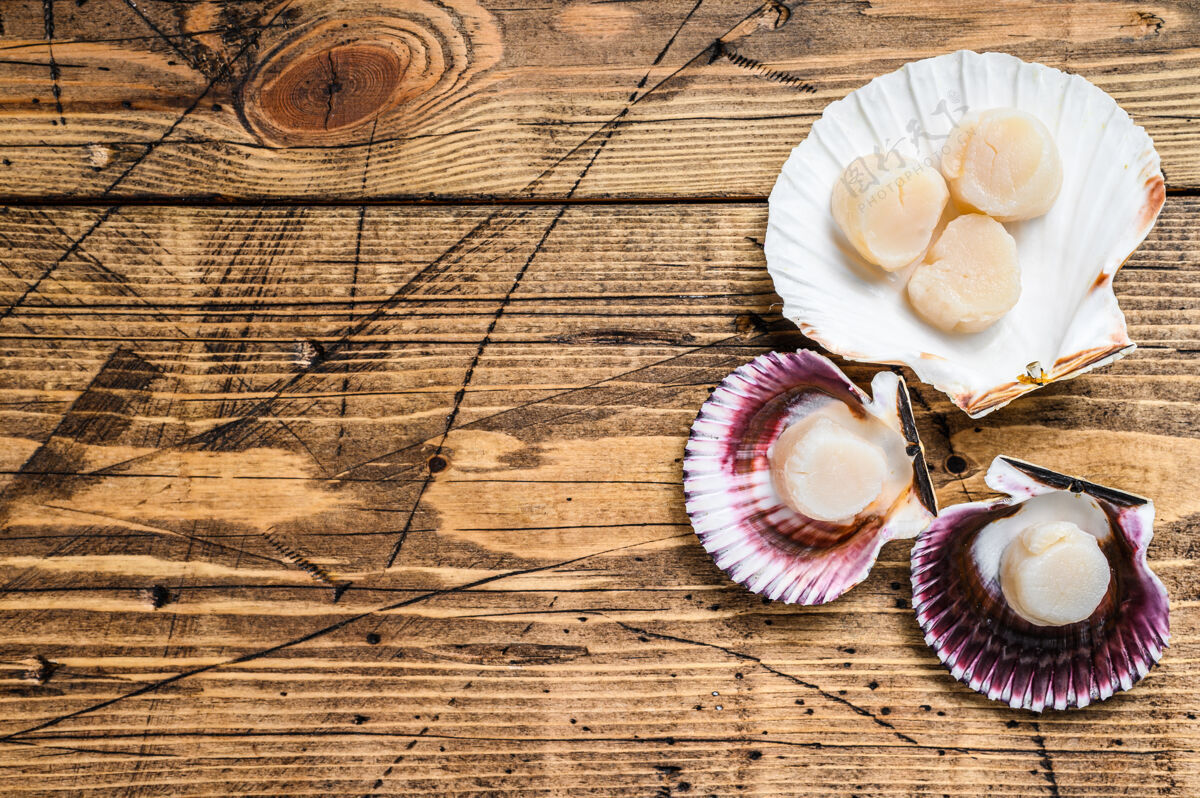烹饪生海鲜扇贝肉放在木壳上桌面查看草药贝壳开胃菜