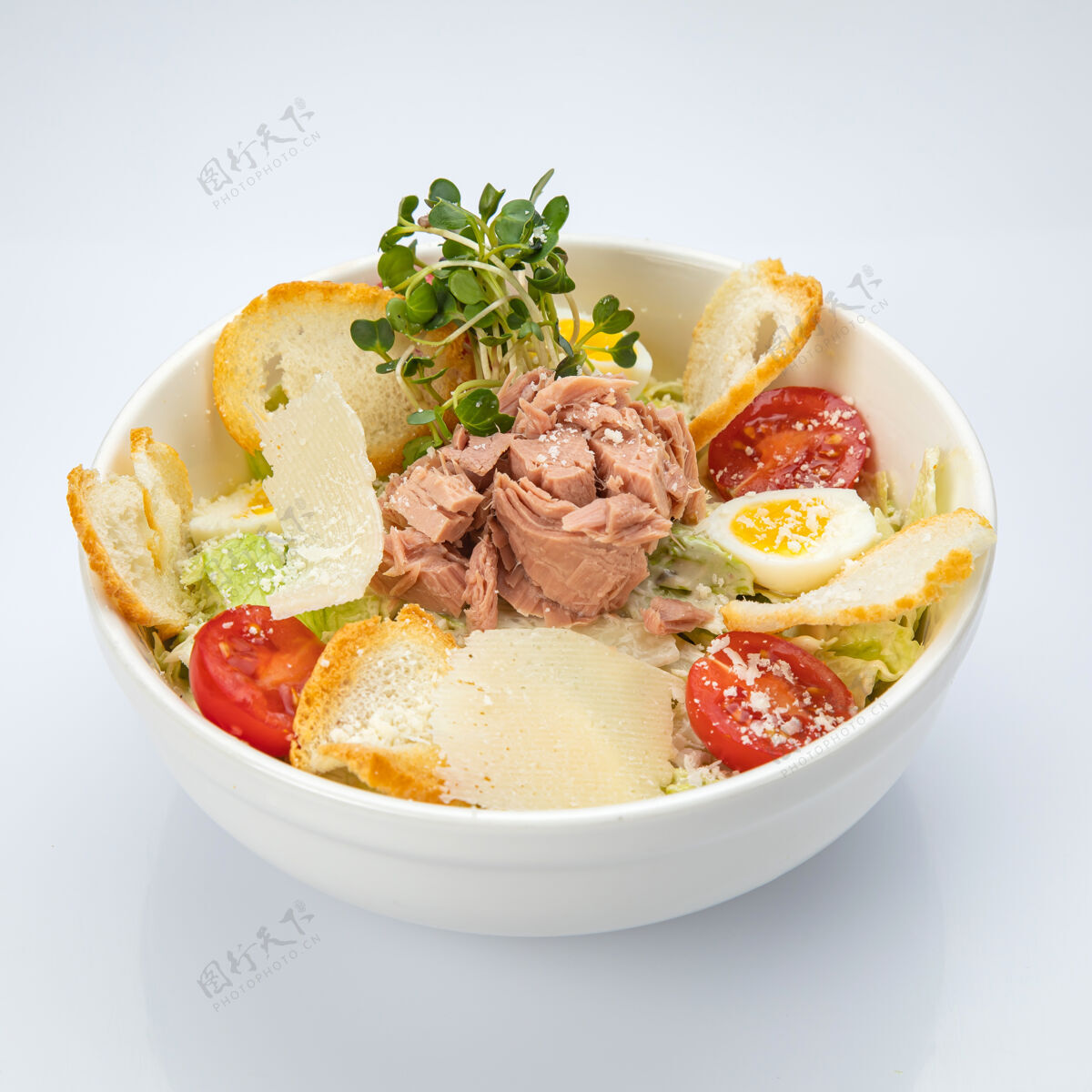 鹌鹑蛋凯撒和罐装金枪鱼在一个白色的孤立背景凯撒沙司绿叶菜面包丁