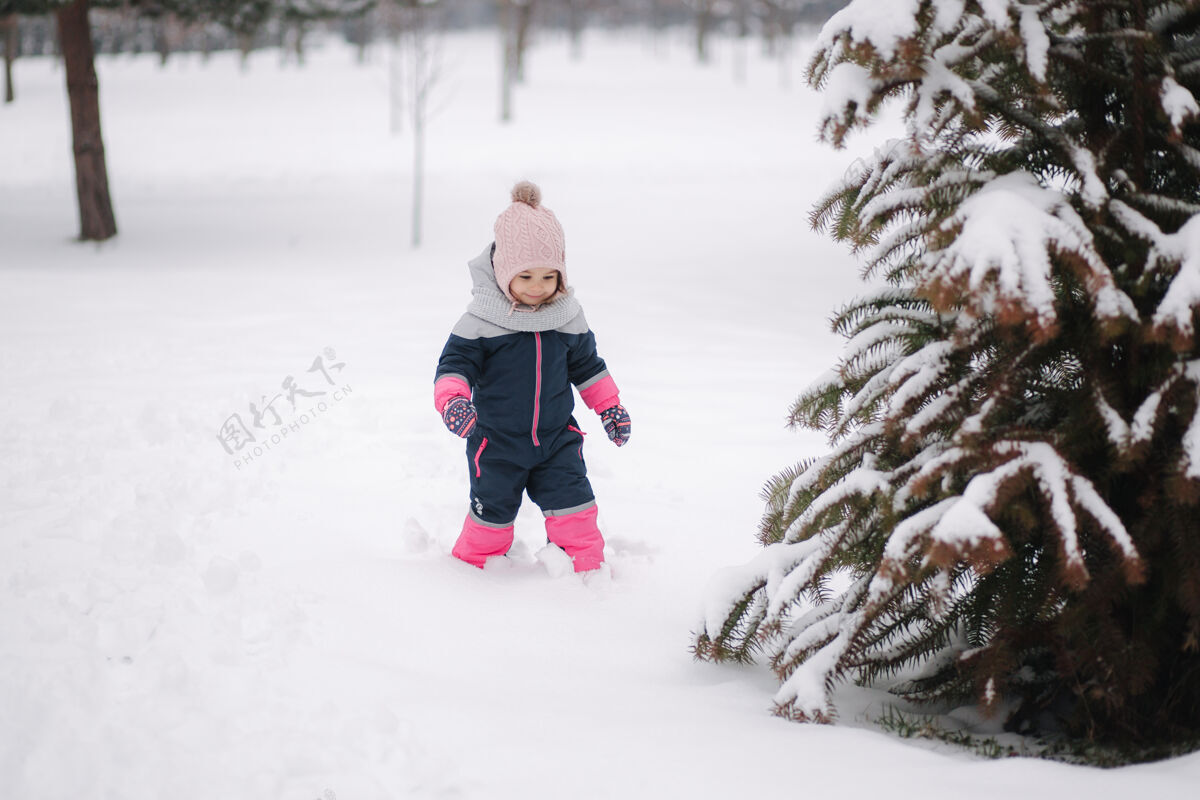 欢呼快乐的小女孩在公园里雪上散步可爱自然父母