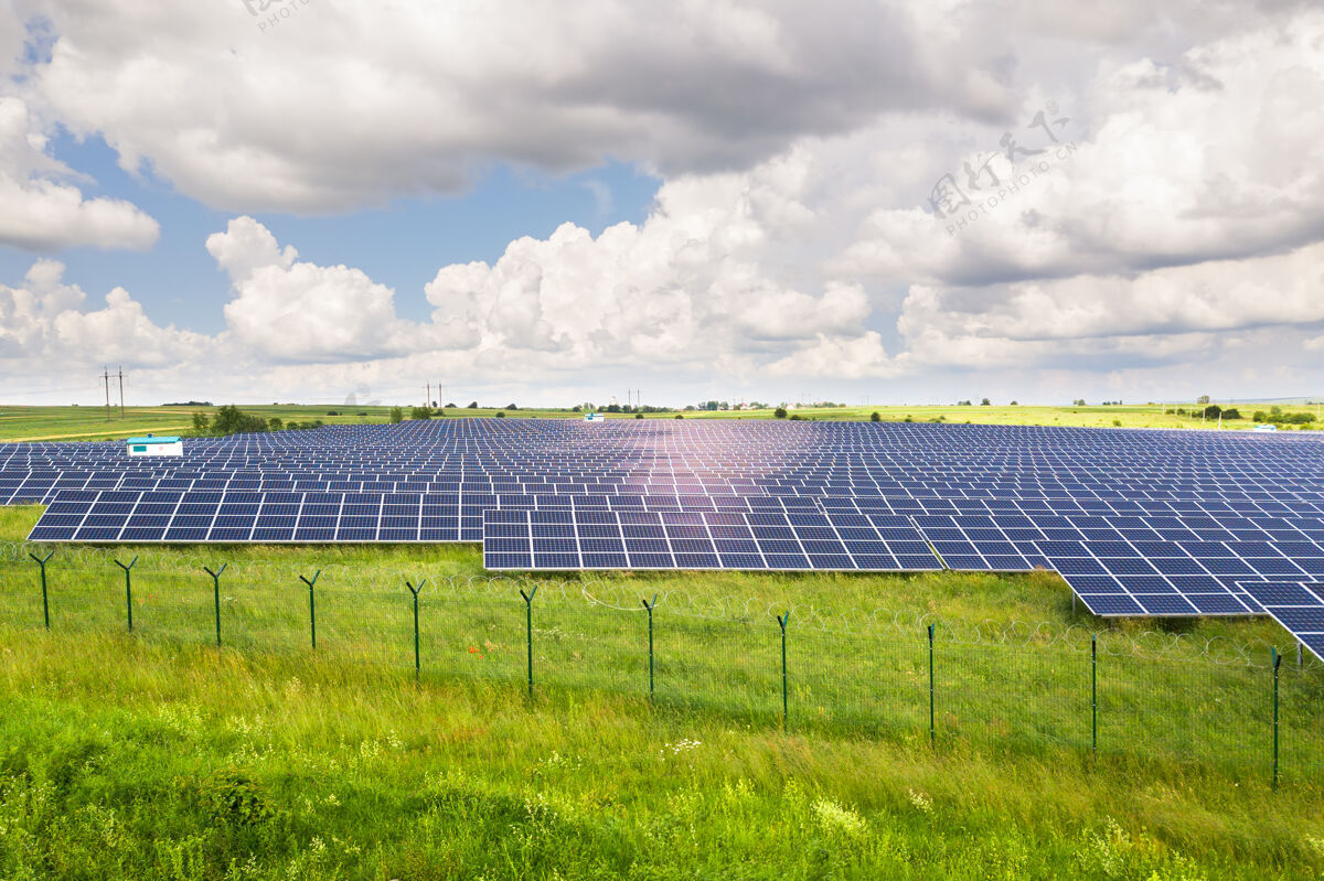 地面周围有防护铁丝网的绿地上的太阳能发电厂鸟瞰图it.电气生产清洁生态能源的面板视图领土环境