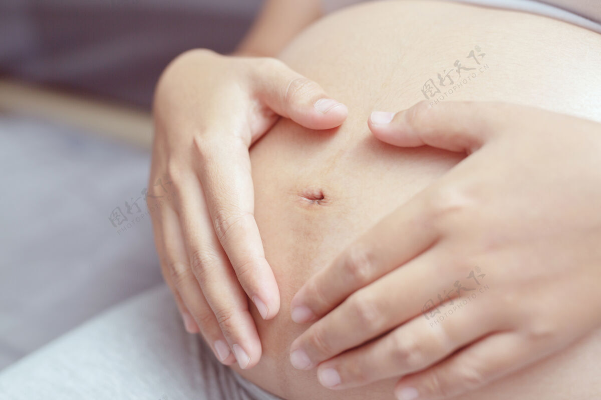 女性新妈妈穿着白色内衣的孕妇用手抚摸肚子和宝宝怀孕生活等待