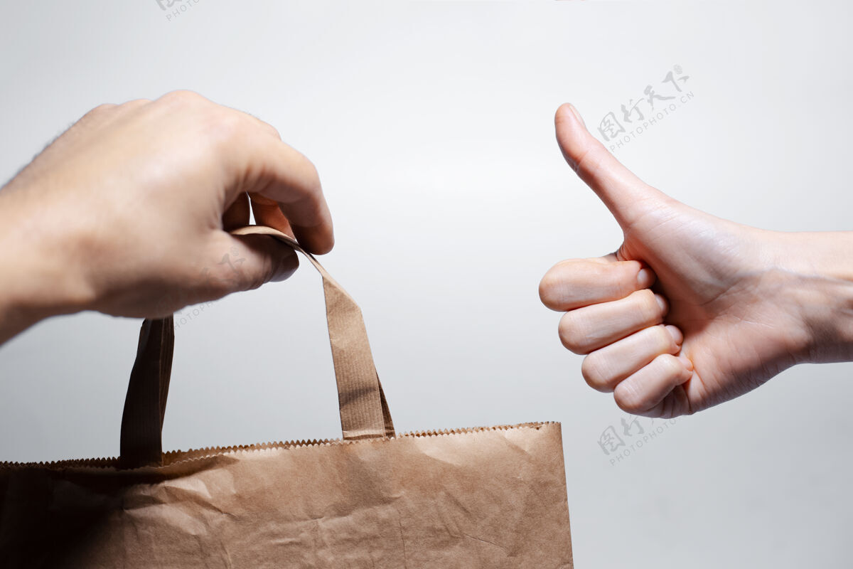盒子男性手持环保纸袋特写送货购物袋填充