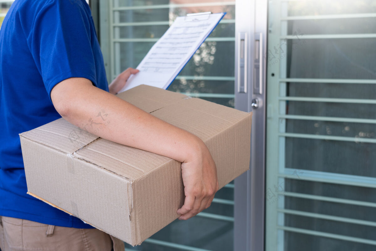 专业身穿蓝色制服的送货员为客户递包裹箱地址购买邮递员