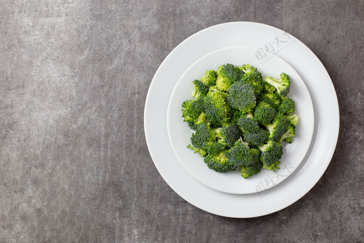 适当的营养把生花椰菜放在深灰色混凝土上的白色盘子里厨房使用开胃菜