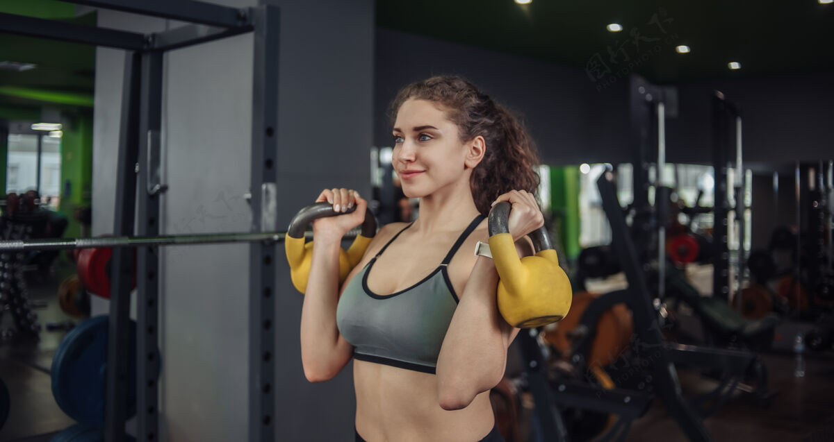 训练体格健壮的年轻女子在户外用壶铃做运动健身房免费举重 功能训练举重力量抱持