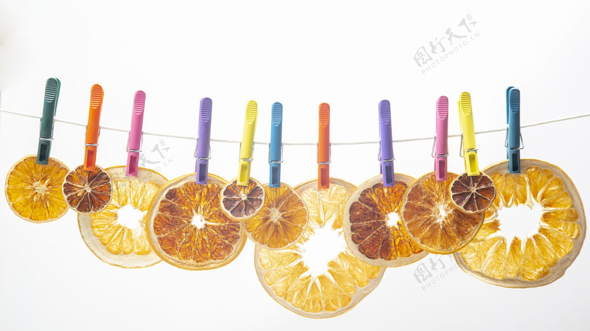 脐带不同柑橘类水果的干片挂在彩色的衣夹上别针颜色绳子
