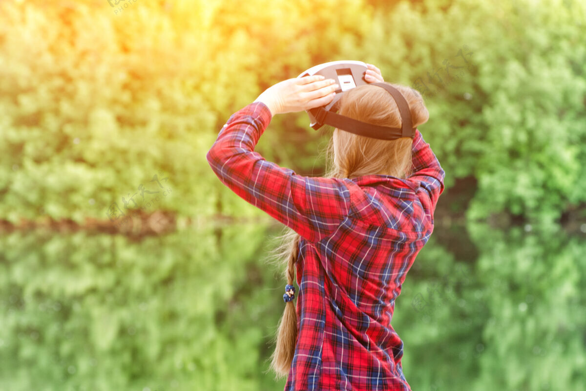 背部女孩拍摄虚拟现实眼镜 日落在自然中 从后面看创新现实视频