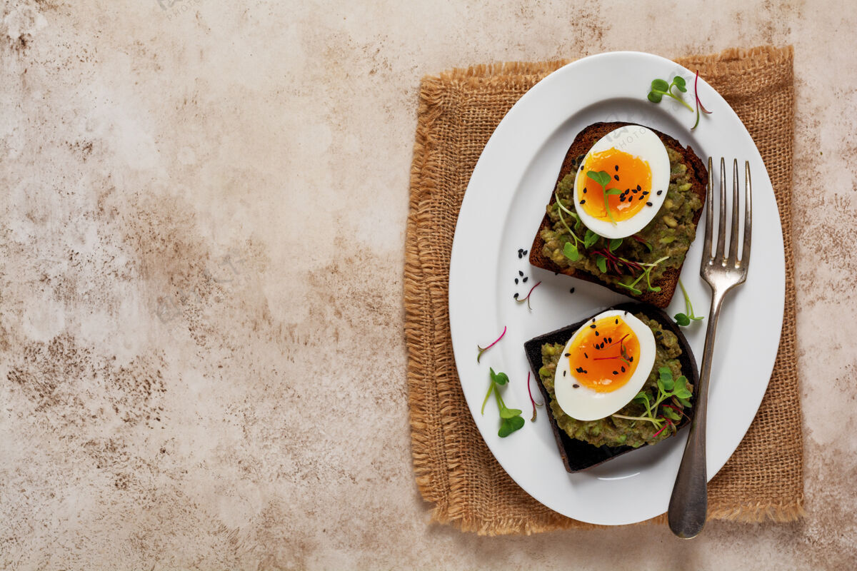 新鲜健康的三明治 鳄梨 鸡蛋和微绿面包 放在一个盘子里 供客人享用早餐健康营养膳食概念.top查看开胃菜全麦鳄梨
