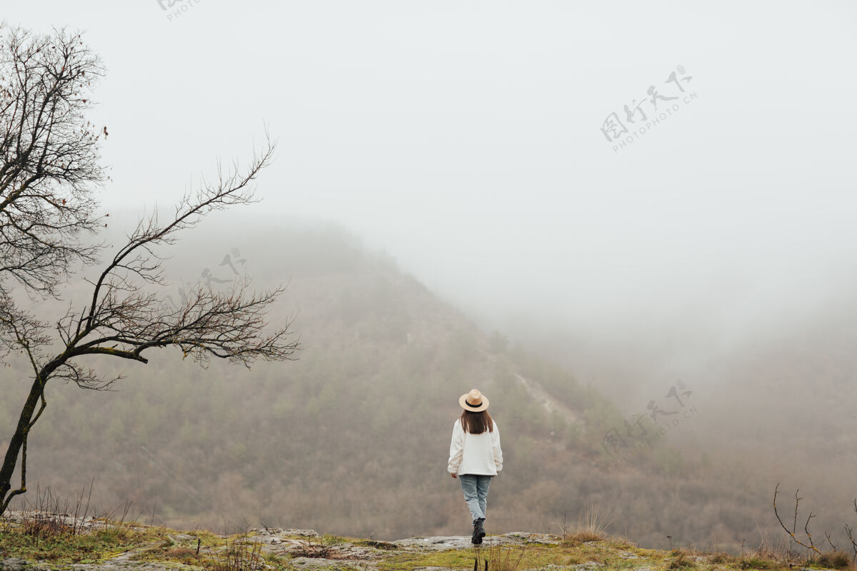 环境在山顶上的女孩旅行者与惊人的视图.大气马上女性雾情感