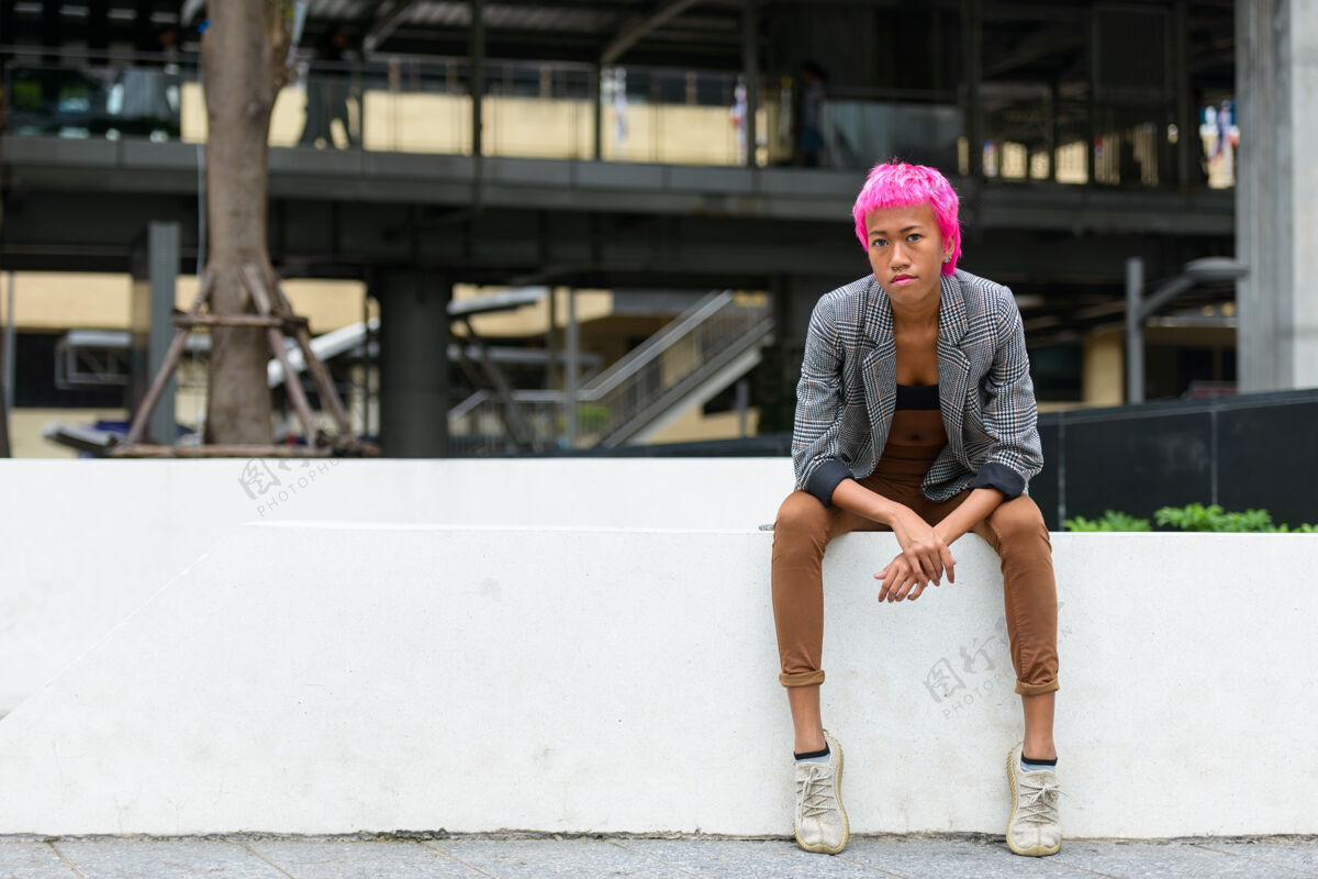 风格年轻叛逆的亚洲女商人的画像 粉红色的头发 在城市街道户外镜头身体企业
