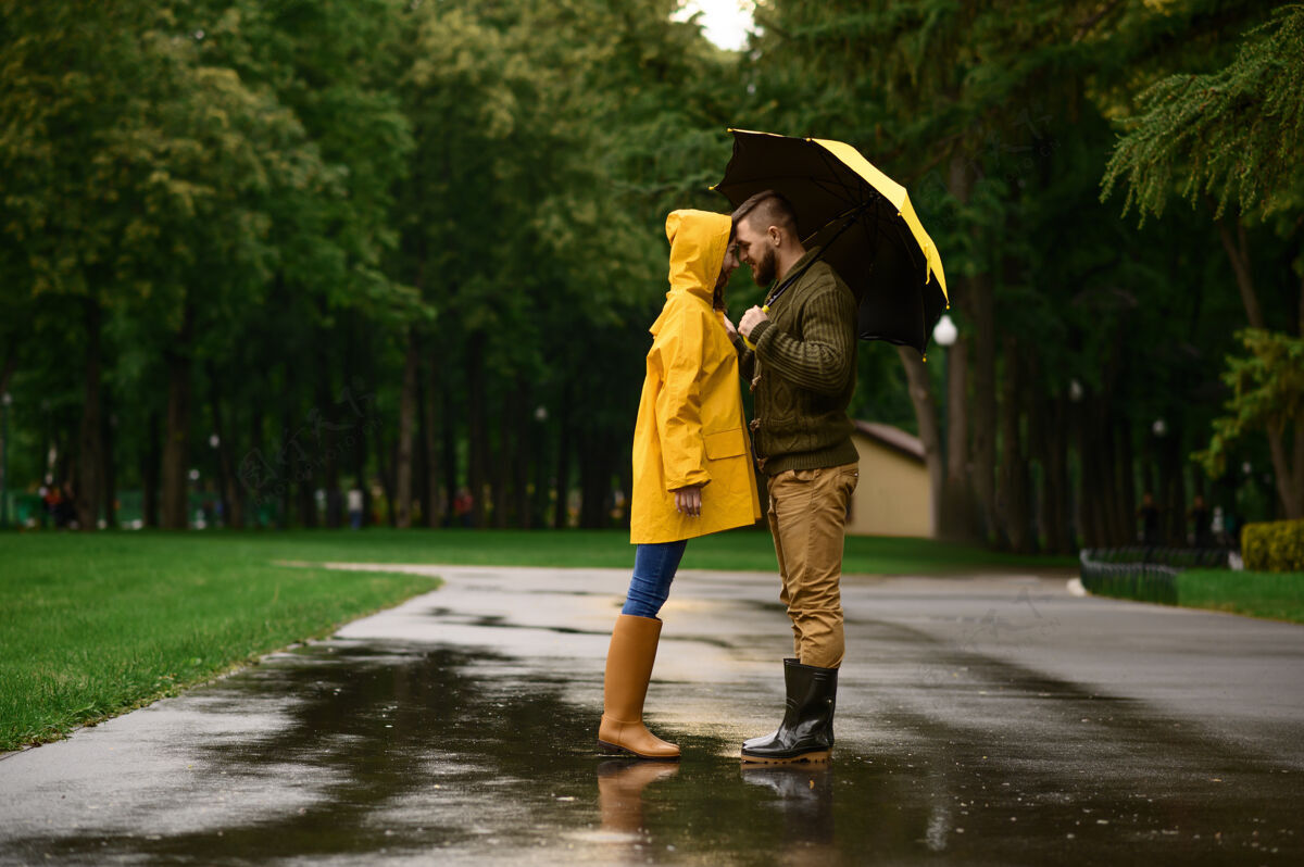 拥抱一对幸福的情侣在公园里互相发誓 夏日多雨戴曼雨伞下的女人 散步路上的浪漫约会 小巷里的潮湿天气人类男人女人