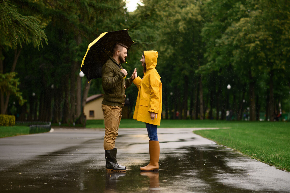 关系一对幸福的情侣在公园里互相发誓 夏日多雨戴曼雨伞下的女人 散步路上的浪漫约会 小巷里的潮湿天气一对男人男朋友