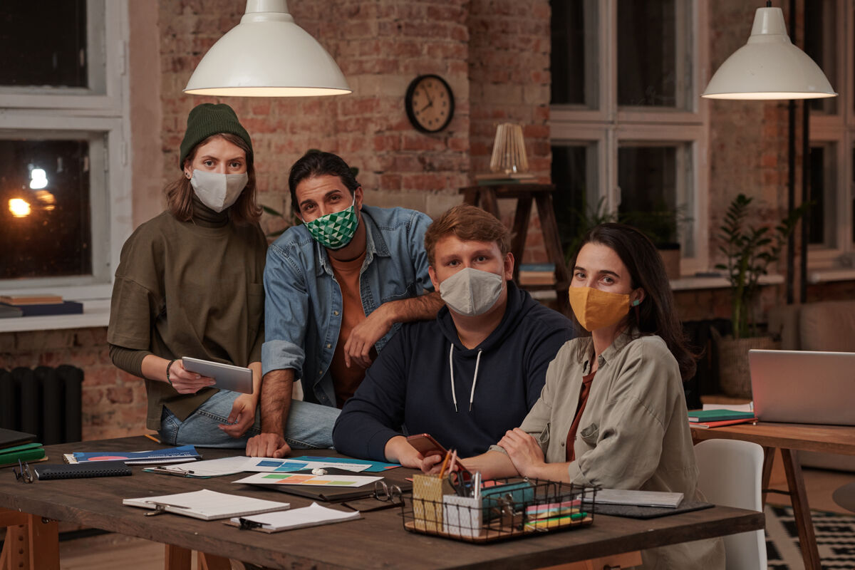 成人一组戴着防护面具的设计师在办公室工作时注视前方的肖像桌子职业商务女性