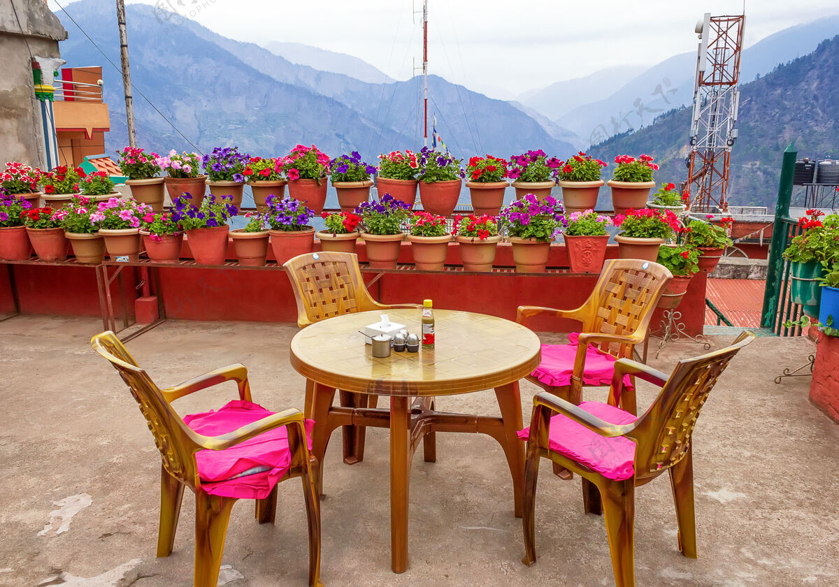 花带桌椅和鲜花的阳光露台波特山视图.nepal!花 山 椅子 壶 尼泊尔 阳台 露台