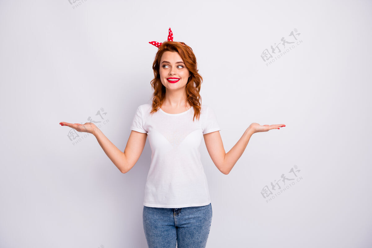 时尚她的肖像她漂亮迷人可爱开朗活泼的女孩拿着两只手掌广告宣传品空间决定隔离在淡白色粉彩墙上Pinup好奇粉彩
