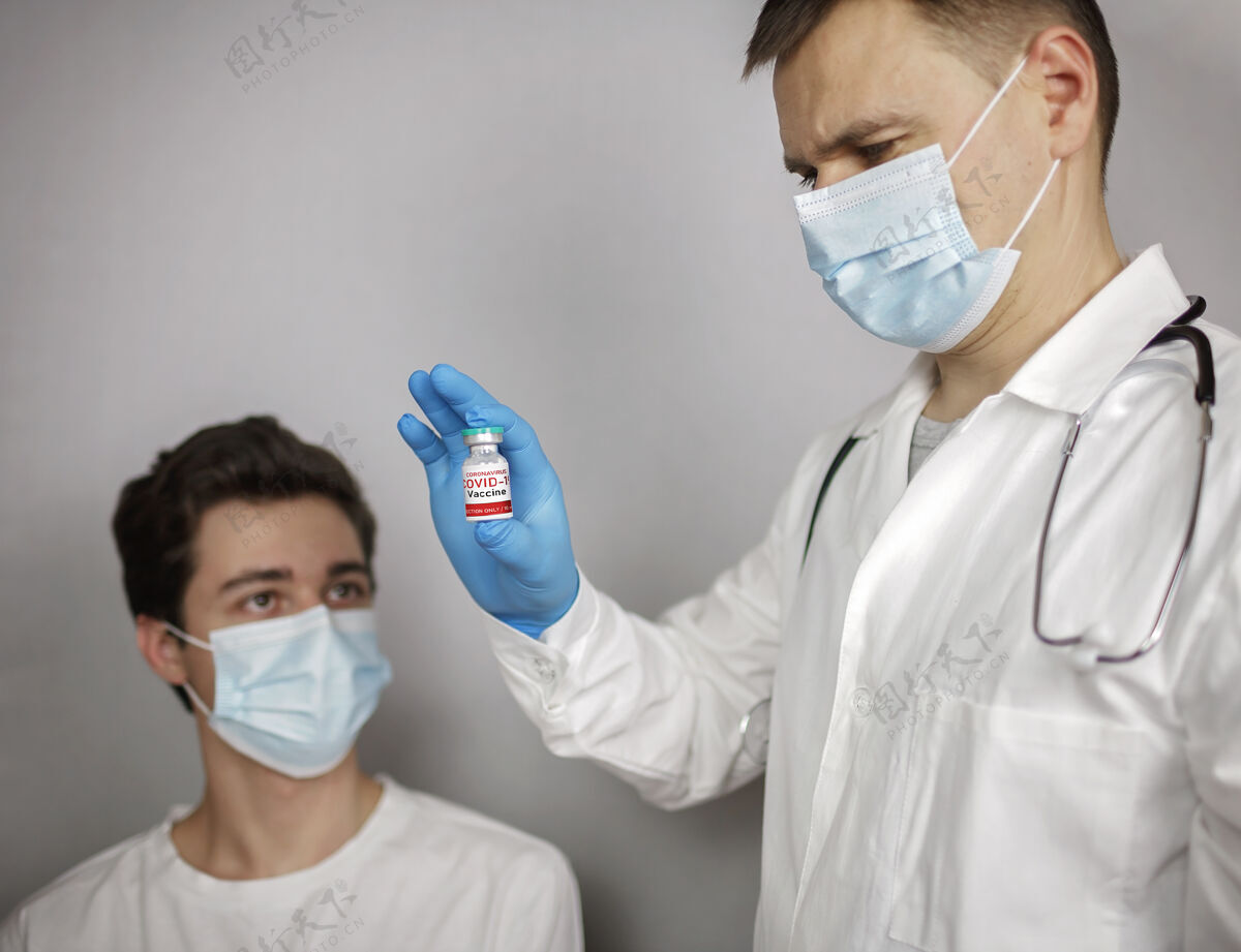 瓶子医生戴着医用口罩和手套 拿着装有冠状病毒疫苗的安瓿和注射器治疗疫苗手臂