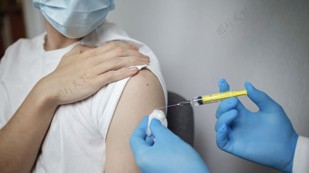 治疗医生戴着医用口罩和手套 拿着装有冠状病毒疫苗的安瓿和注射器注射注射免疫