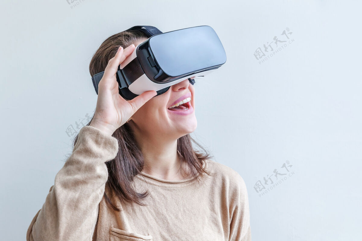 3d微笑的年轻女子戴着虚拟现实vr眼镜头盔耳机在白色背景上想象设备体验