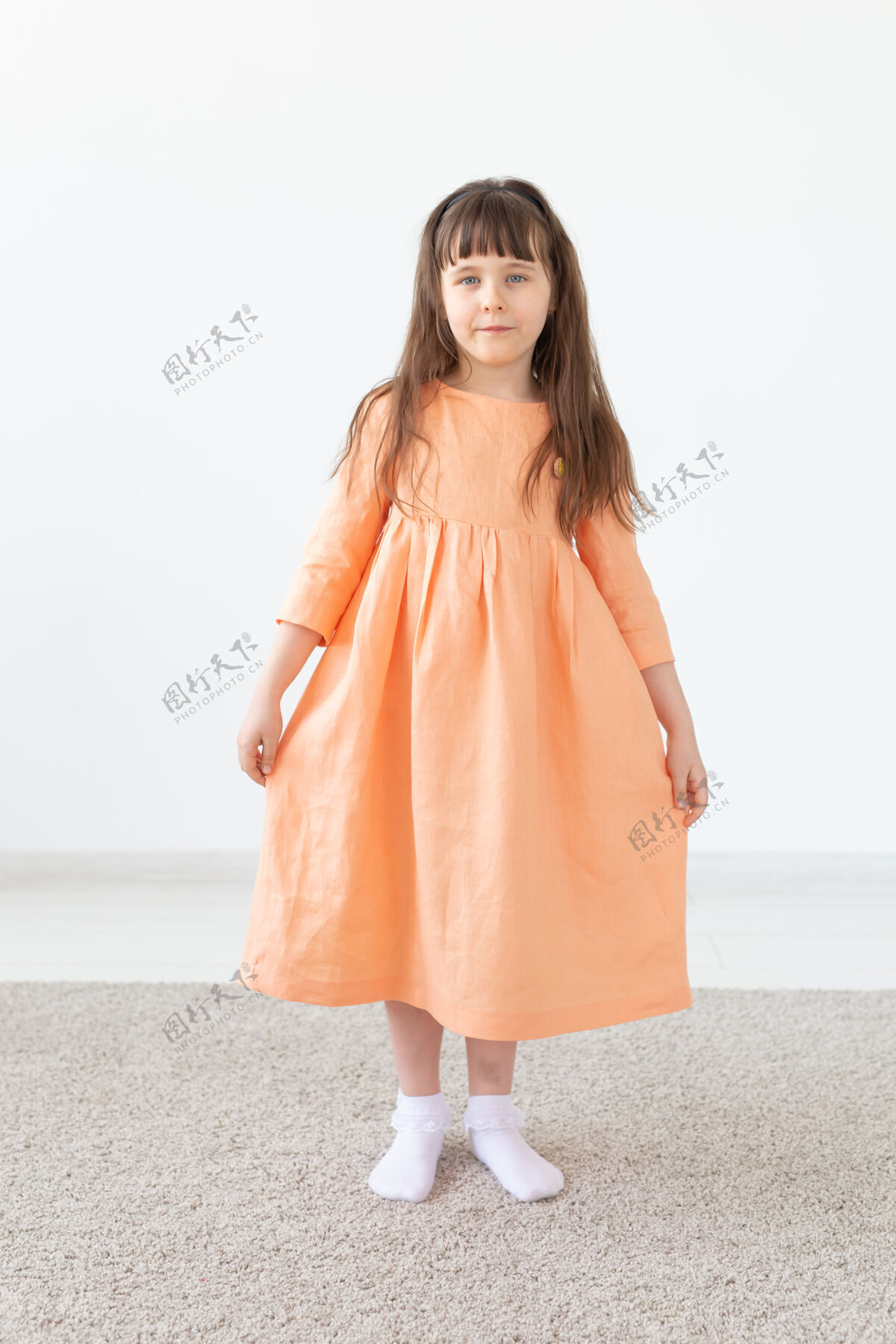 漂亮一个穿桃红色衣服的孩子对着白墙摆姿势小穿着儿童