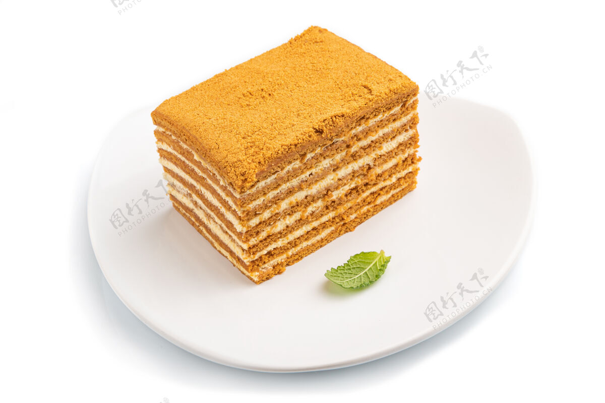 卡路里自制蜂蜜蛋糕与牛奶奶油和薄荷隔离在白色表面薄荷曲奇糖