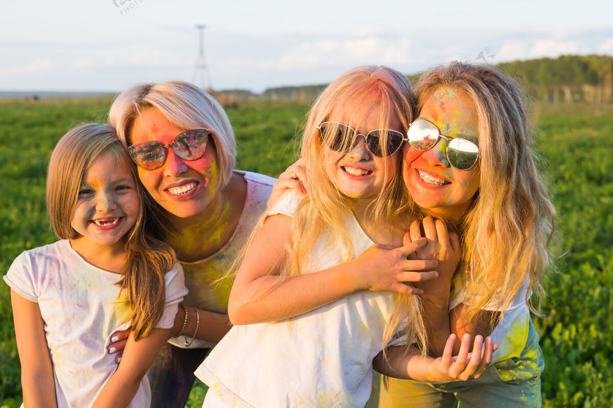 游行胡里节 友谊 幸福和节日的概念-小女孩和戴眼镜的妇女拥抱在胡里节大笑潮人孩子