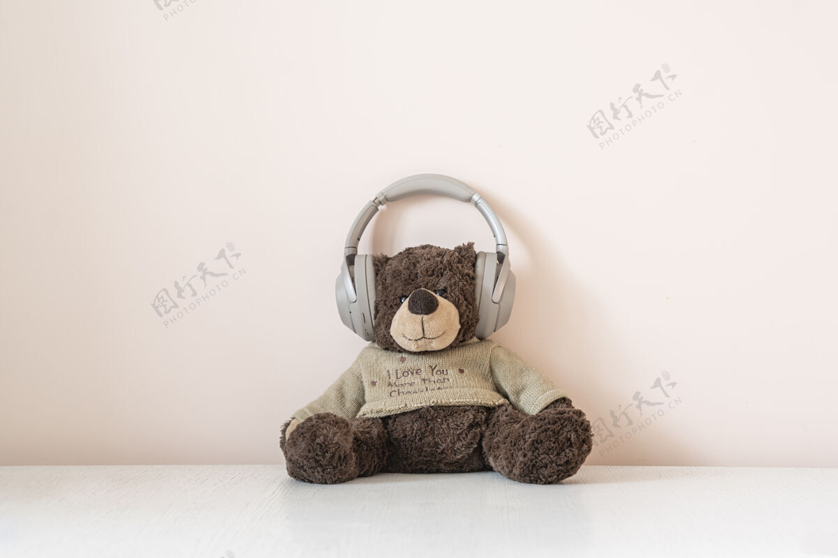 音量泰迪熊戴着耳机听收音机里的音频音乐头迪斯科孩子