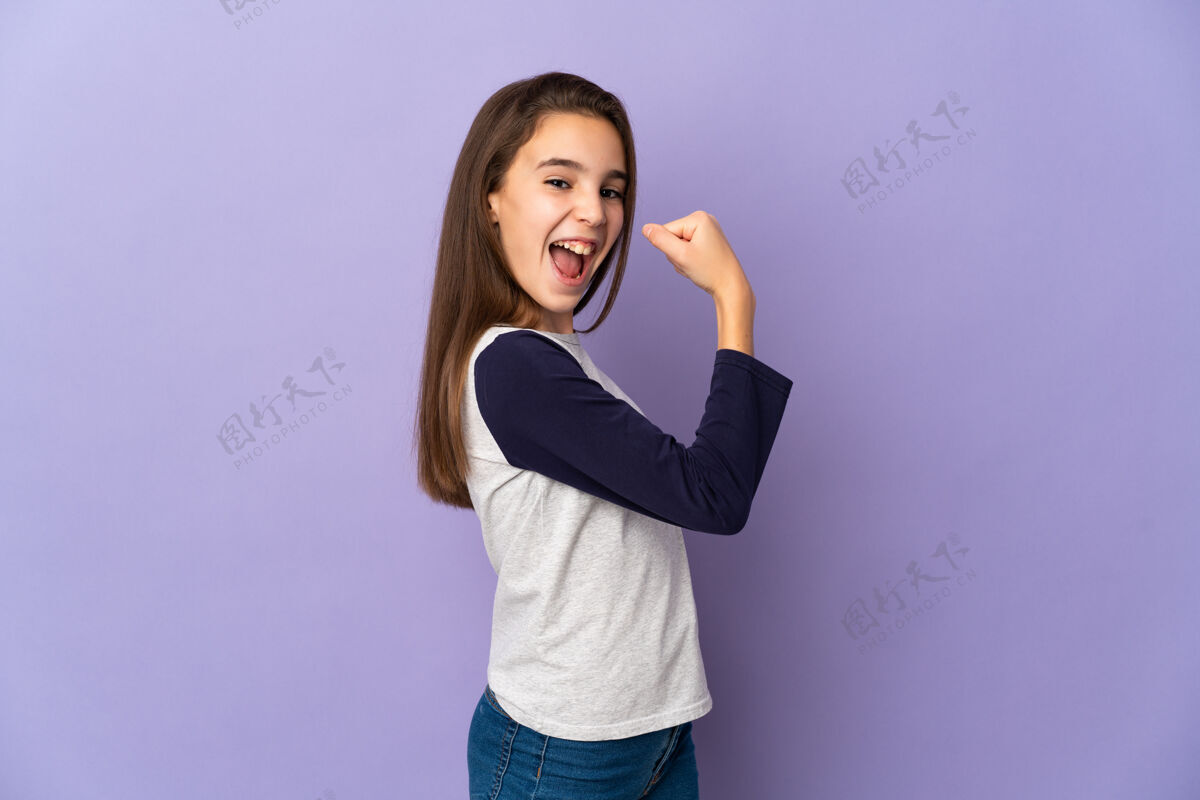 可爱小女孩孤零零地站在紫色的墙上庆祝胜利模特有趣微笑