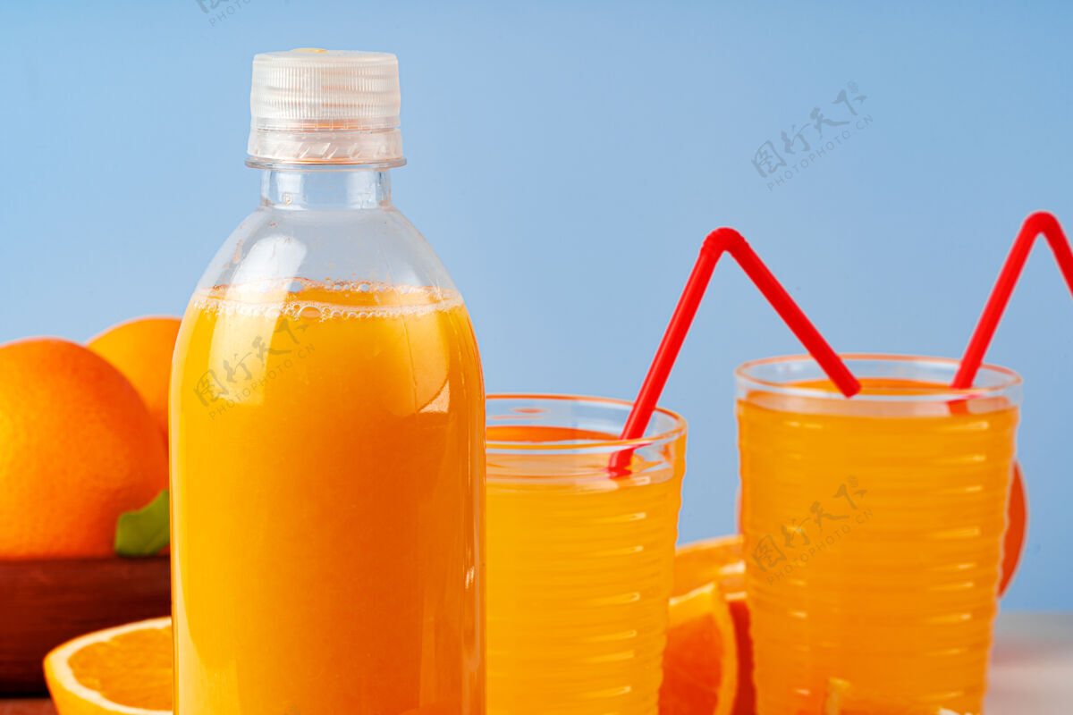 有机桌上摆着一瓶橙汁和新鲜橙子饮食瓶装柑橘