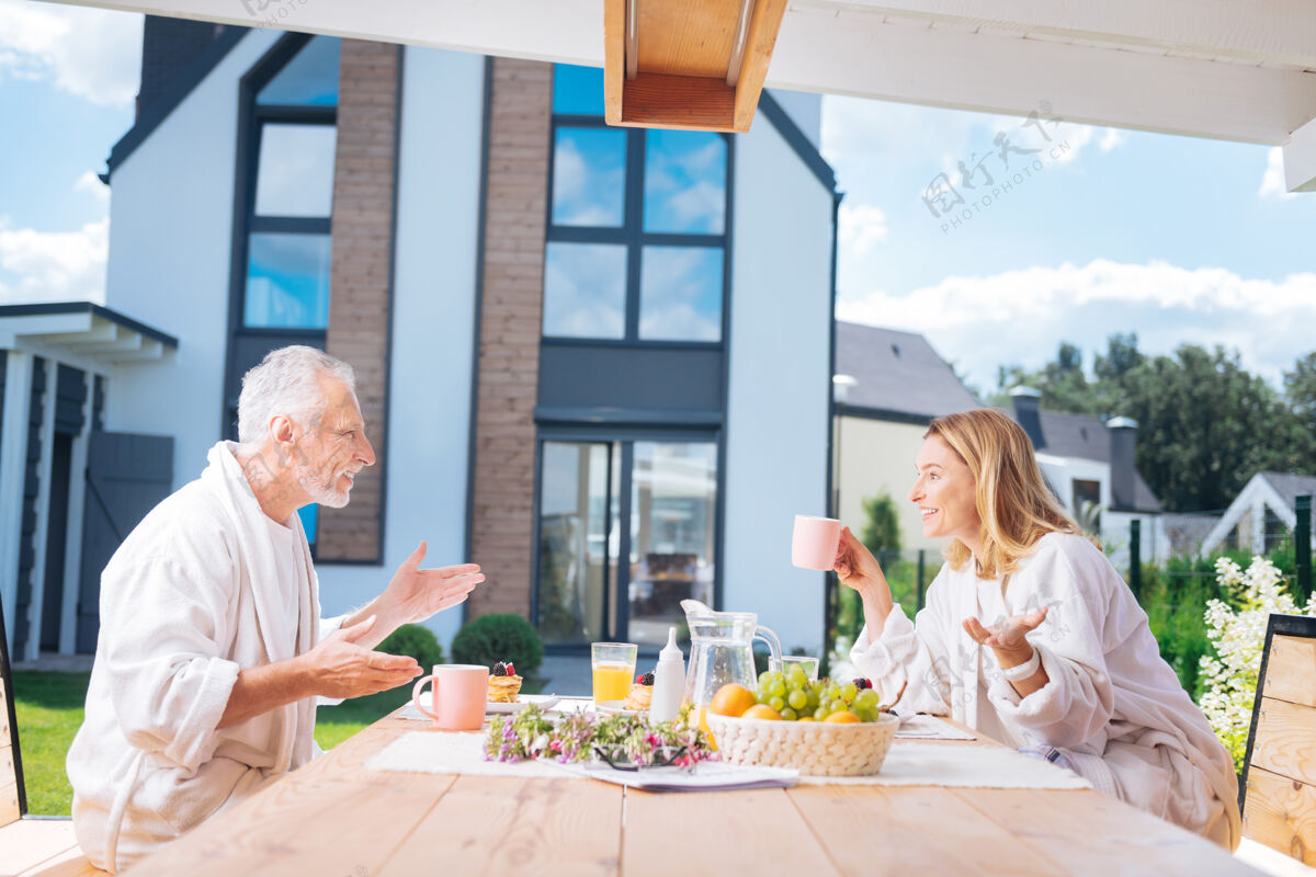 家庭喜气洋洋的夫妻一边吃早餐一边谈情说爱 心情愉快放松水果梁