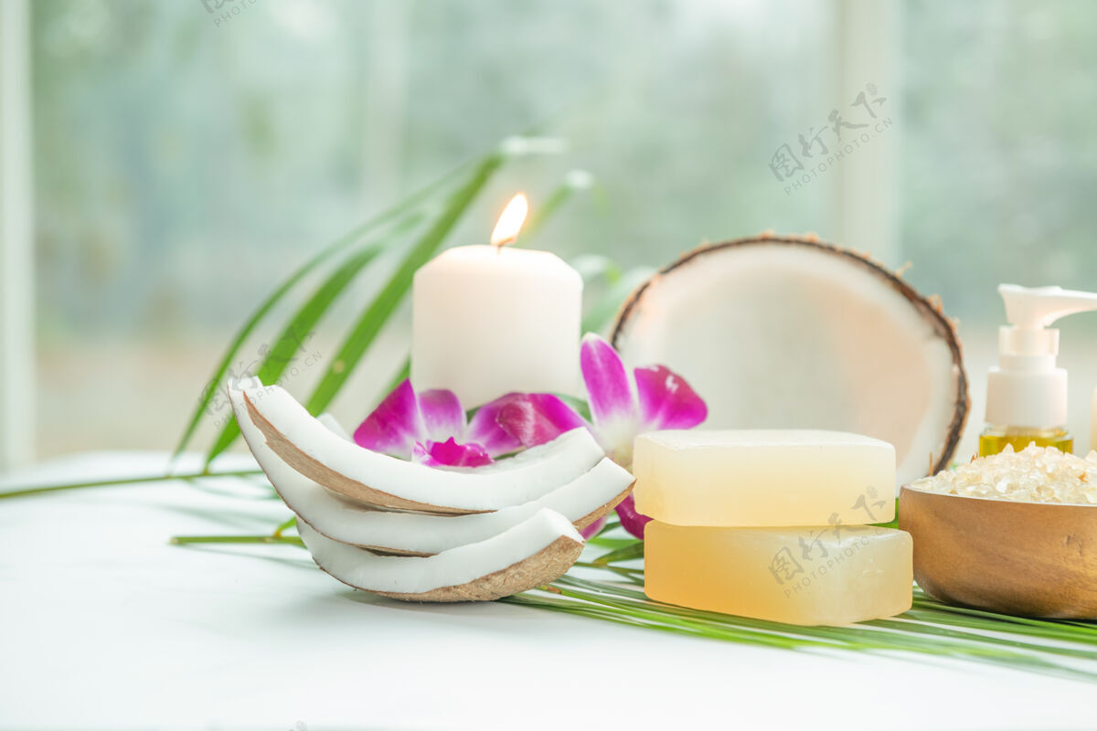 精华椰子油 热带树叶和新鲜椰子轻木表面的spa椰子产品蜡烛棕色可可