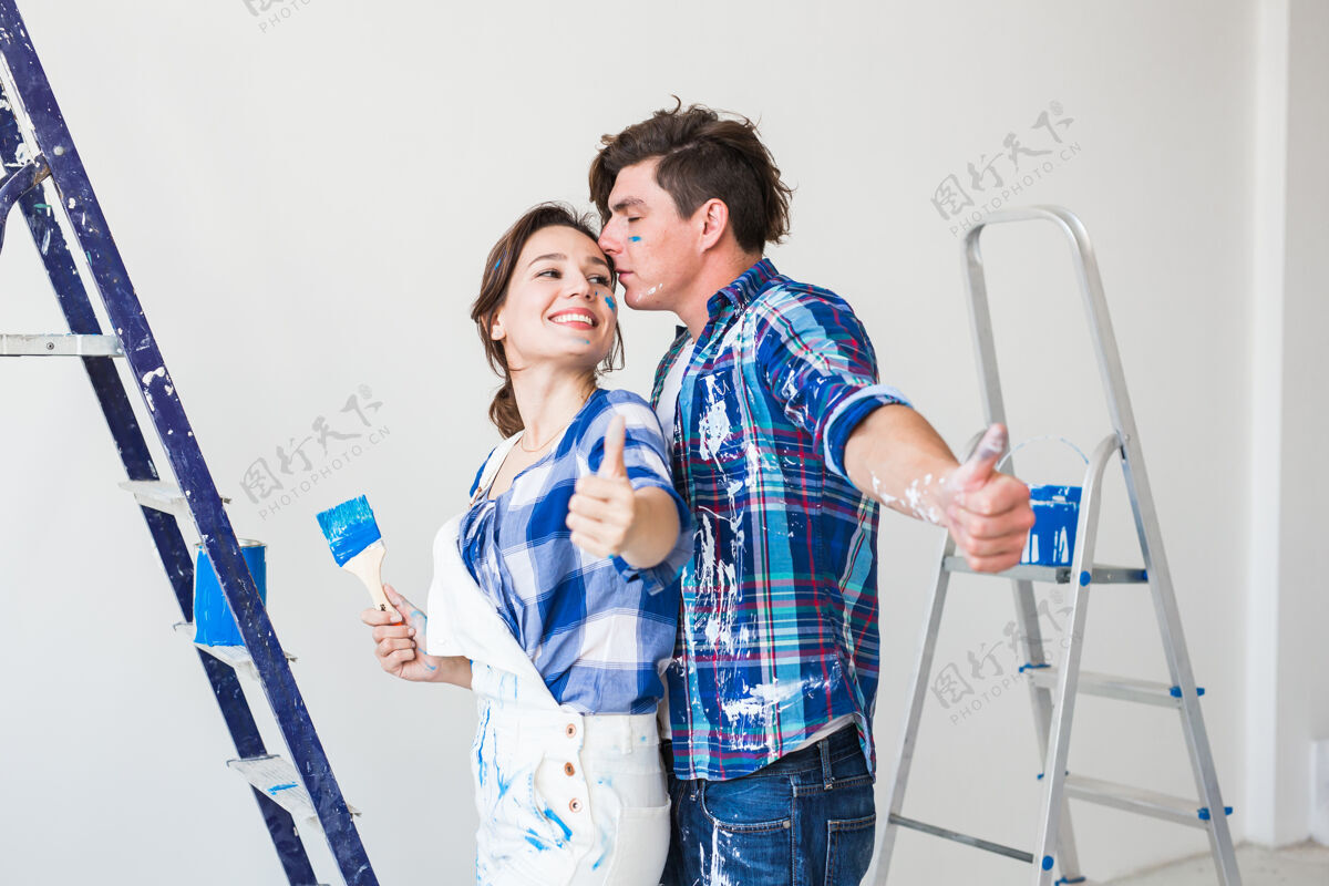 微笑修缮翻新和人的概念女人和男人竖起大拇指室内梯子公寓