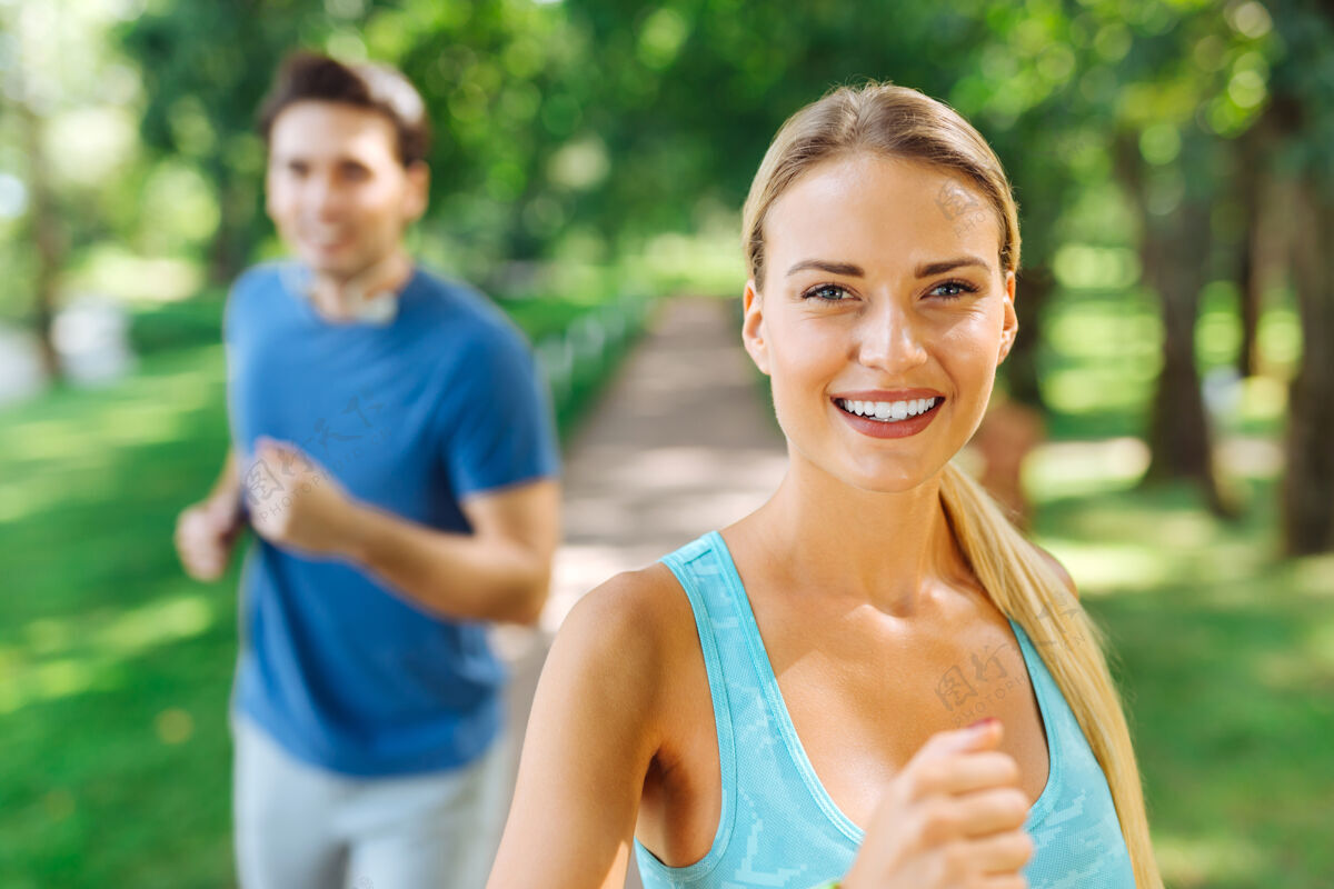 有氧积极的心情快乐的好女人微笑着在公园里享受跑步男人环境女人