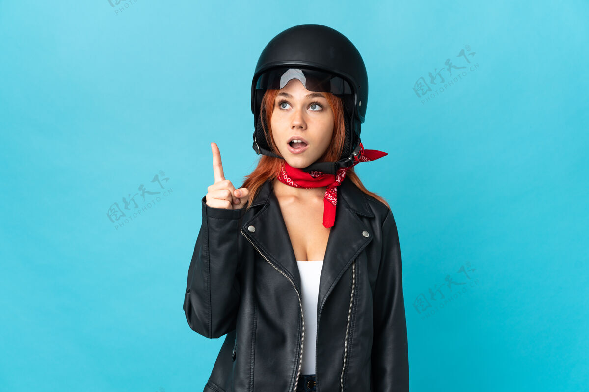 想象年轻的摩托车手拿着摩托车头盔不知所措问题表情