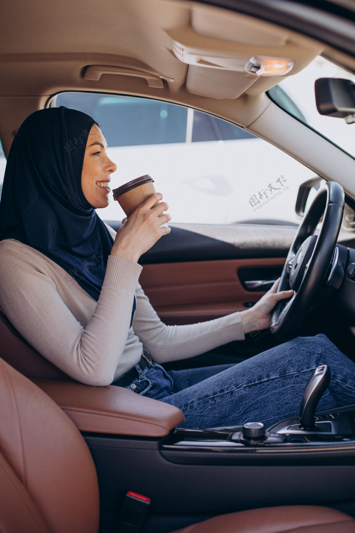 穆斯林年轻的现代穆斯林妇女在车里喝咖啡女人喝酒头巾