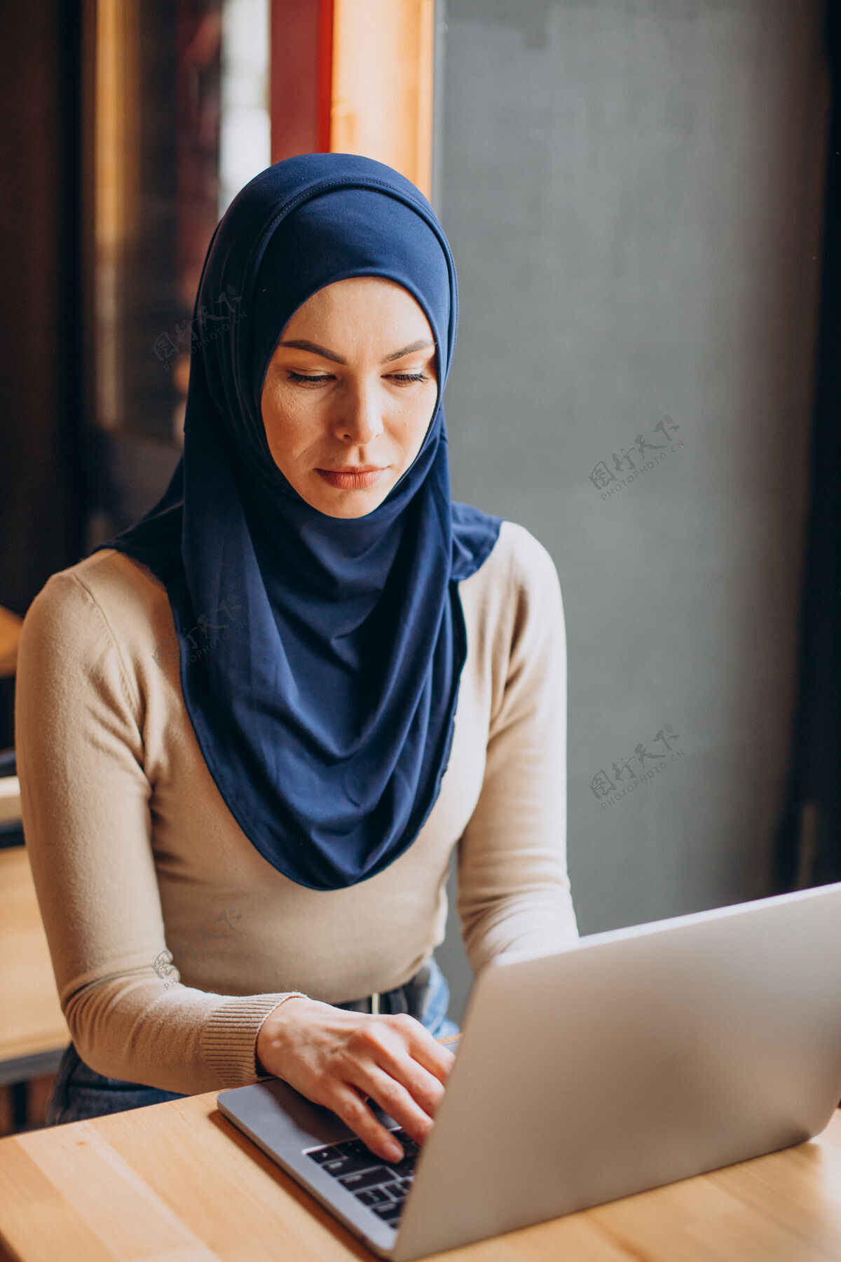 宗教现代穆斯林妇女在咖啡馆用笔记本电脑工作穆斯林女人商业女性女性