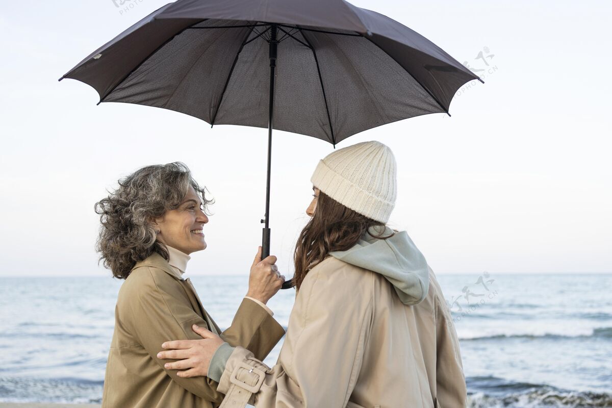 外面母女俩在沙滩上打着伞 分享着温柔的时刻女儿女人水平
