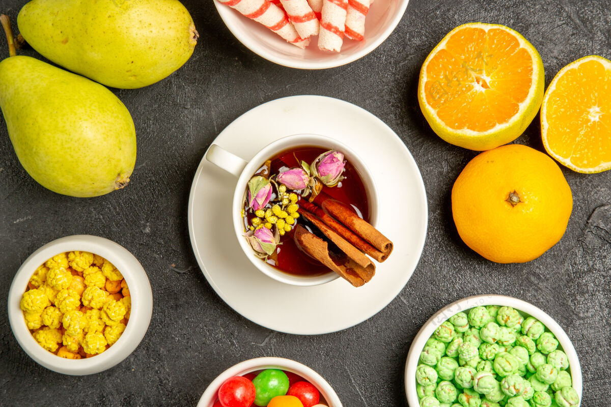 餐厅在灰色空间上俯瞰一杯带有糖果和新鲜水果的茶可食用水果午餐茶杯