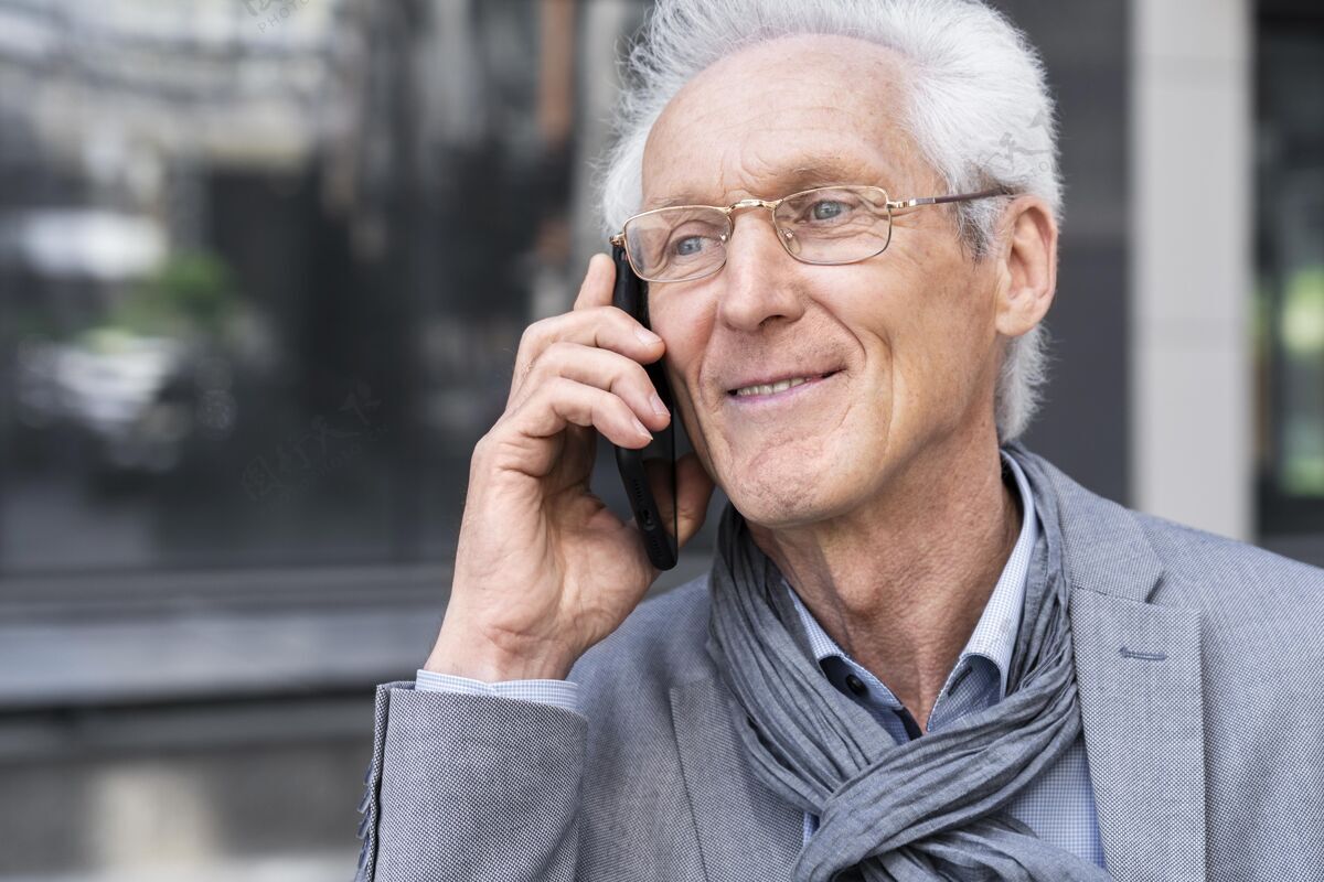 老年人城里的一个老男人在用智能手机聊天老年人城市老年