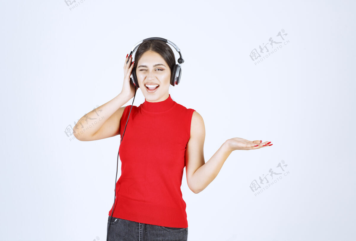 年轻人穿着红衬衫的Dj女孩 戴着耳机 手上拿着什么东西或是什么东西姿势工作人员场景