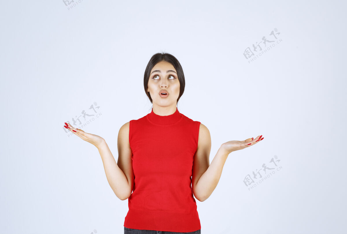 销售穿红衬衫的女孩在她张开的手上展示着什么介绍促销年轻人