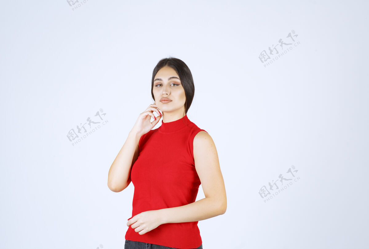 年轻穿红衬衫的女孩摆出中性 积极和吸引人的姿势休闲人类女人