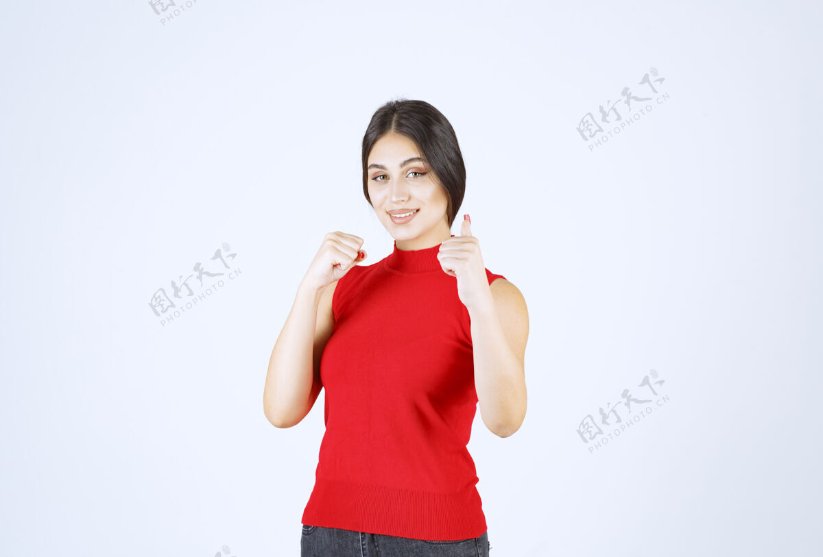 模特穿红衬衫的女孩展示着快乐的手势满意积极女性