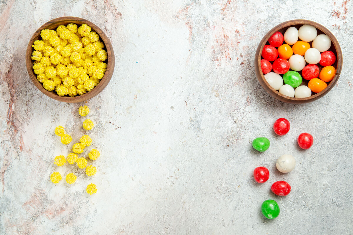 视图顶视图不同颜色的糖果放在白色的桌子上彩色糖果糖玉米胡椒健康