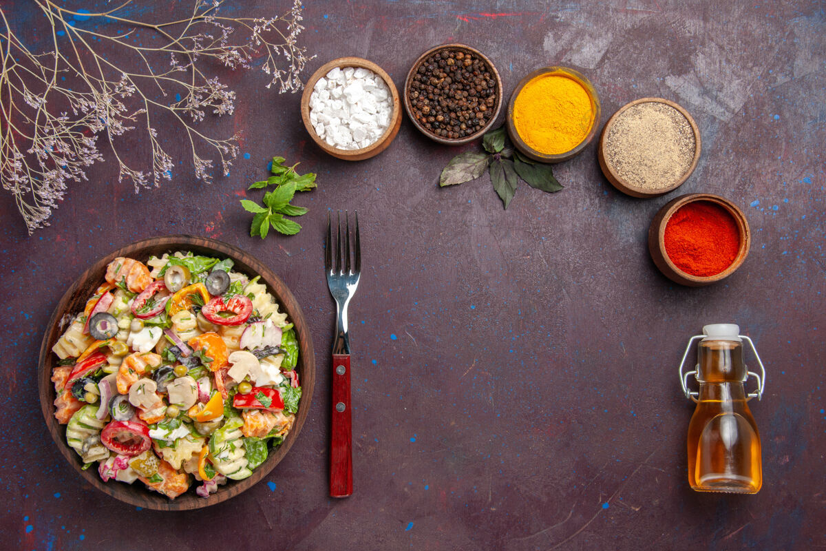 用餐俯瞰美味的蔬菜沙拉与不同调味料的深紫色背景健康饮食蔬菜沙拉午餐盘子饮食调味品