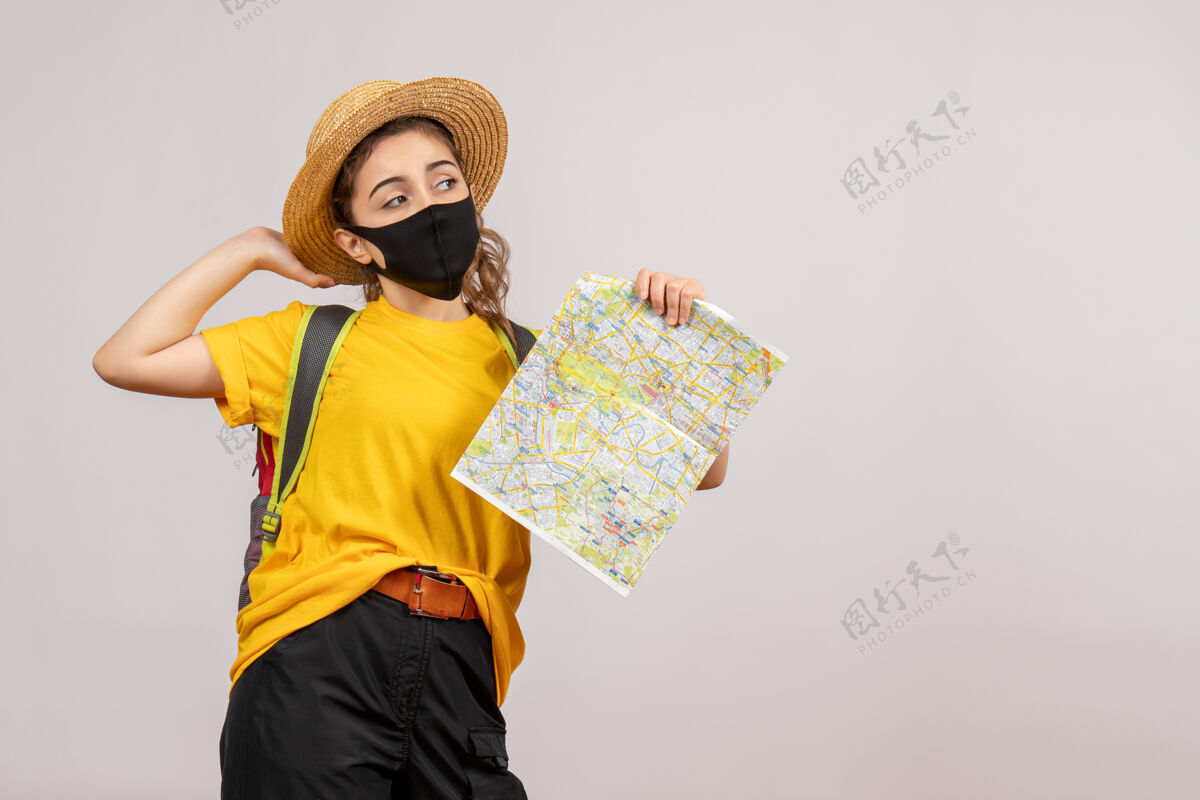 面具正面图身穿黄色t恤的年轻女子举着地图人肖像持有