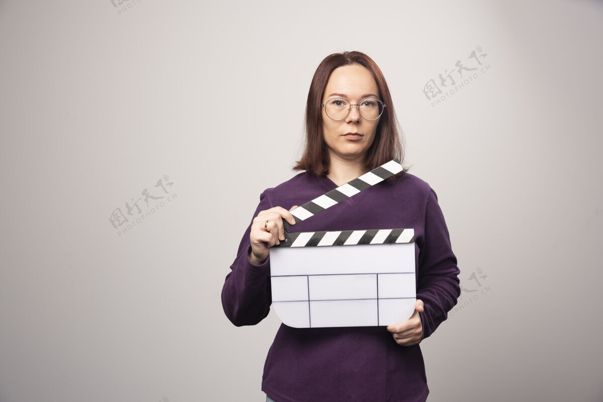姿势一个年轻的女人在一张白色的照片上摆着一个电影院的带子高质量的照片年轻人女士女人