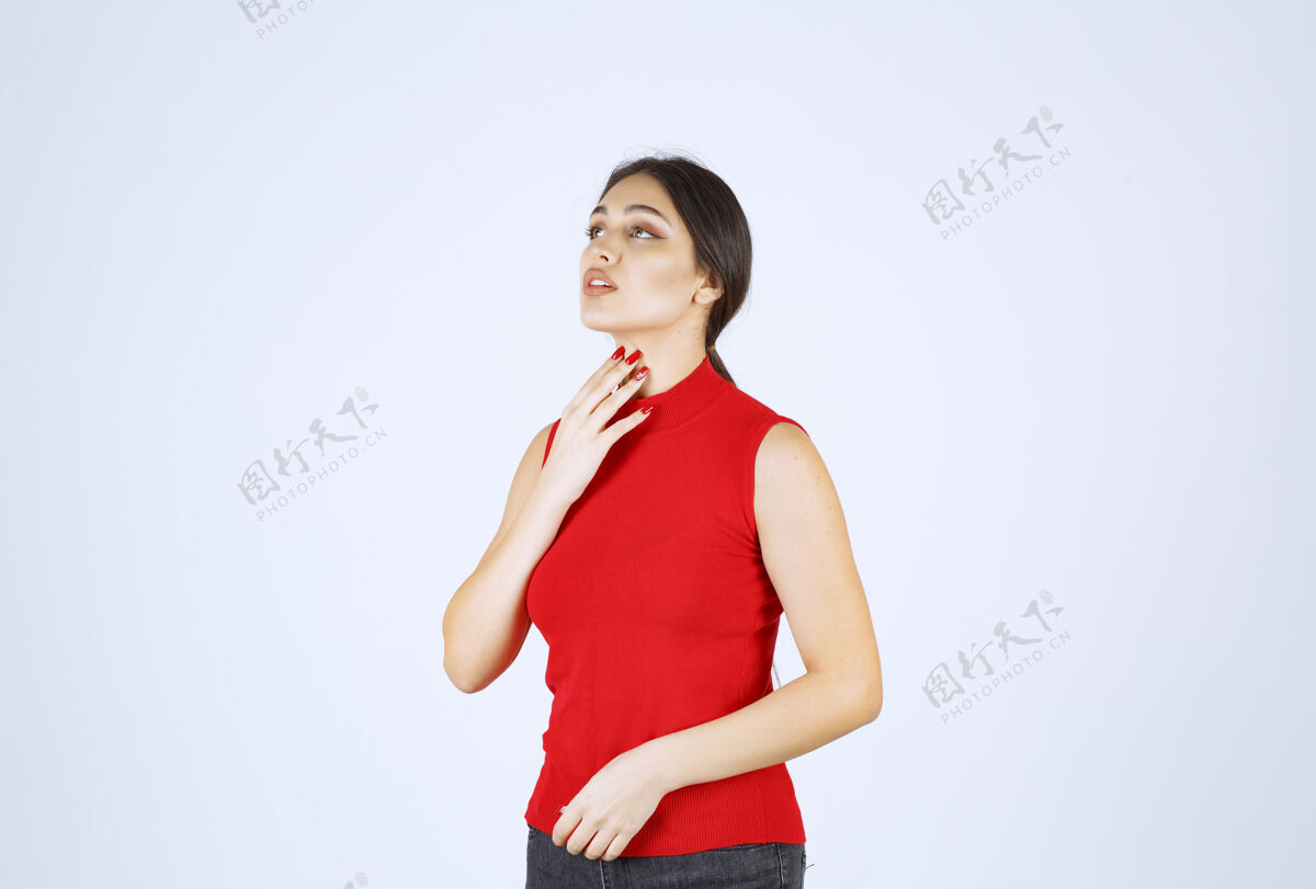 满意穿红衬衫的女孩摆出中性 积极和吸引人的姿势员工年轻人