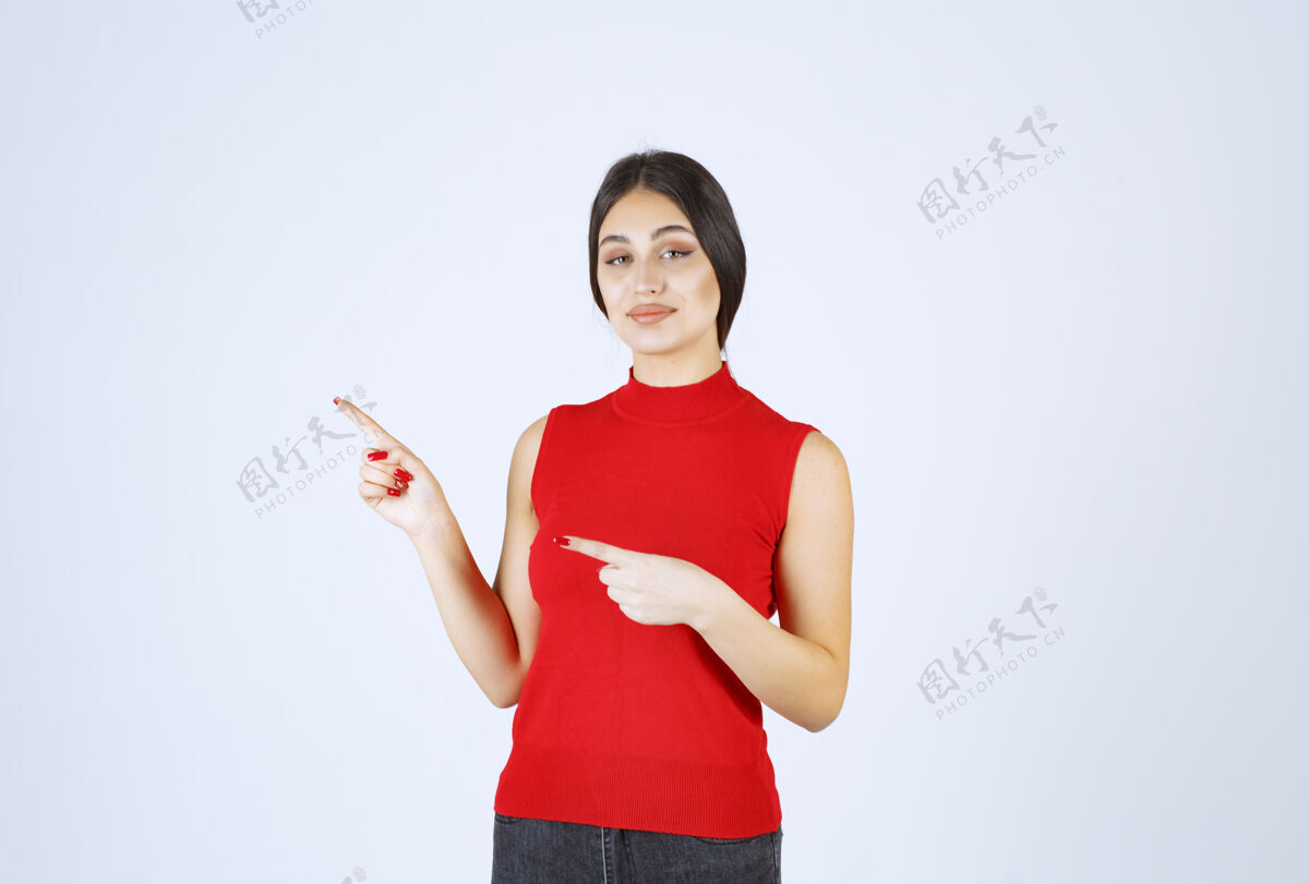 职员穿红衬衫的女孩在展示左边的东西介绍模特年轻人