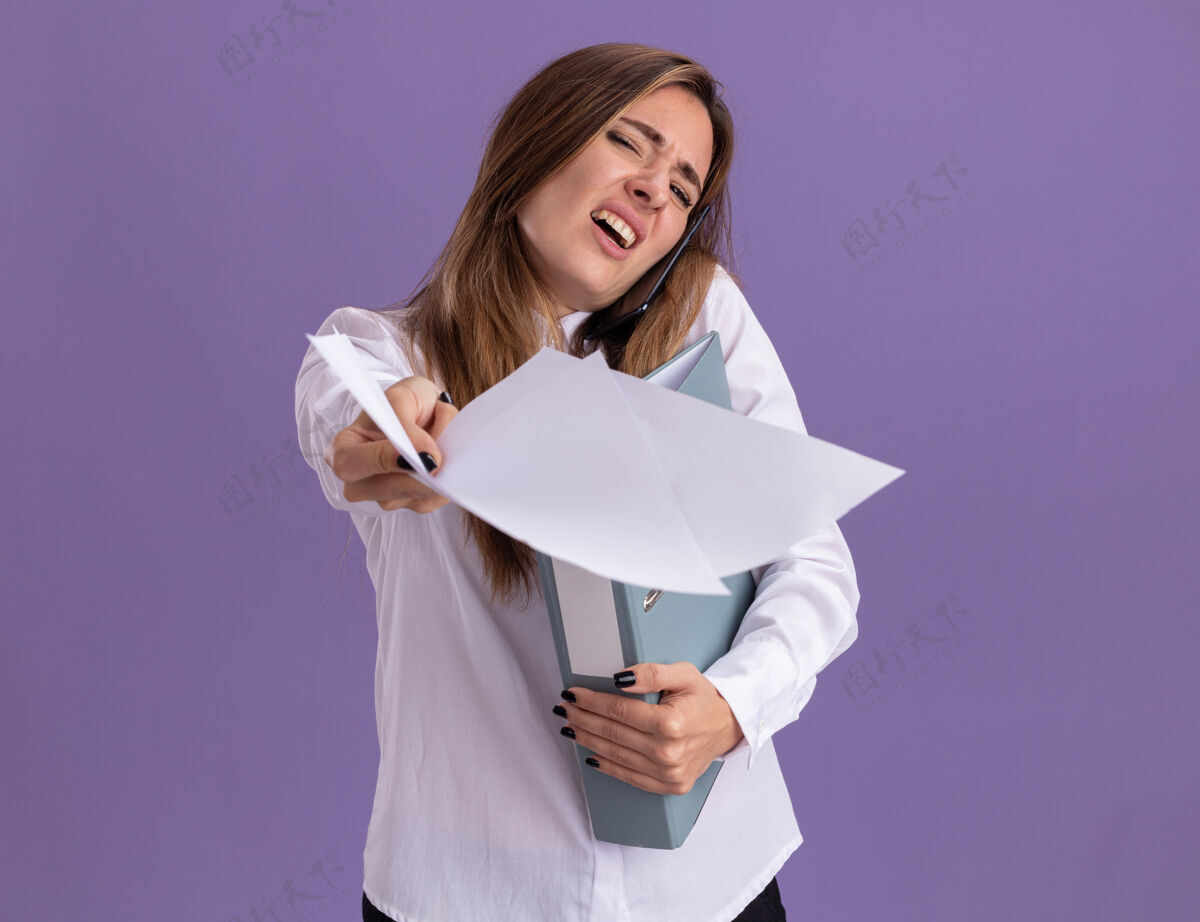 电话一个年轻漂亮的白人女孩拿着一张纸 放着文件夹 一边打电话女孩紫色文件夹