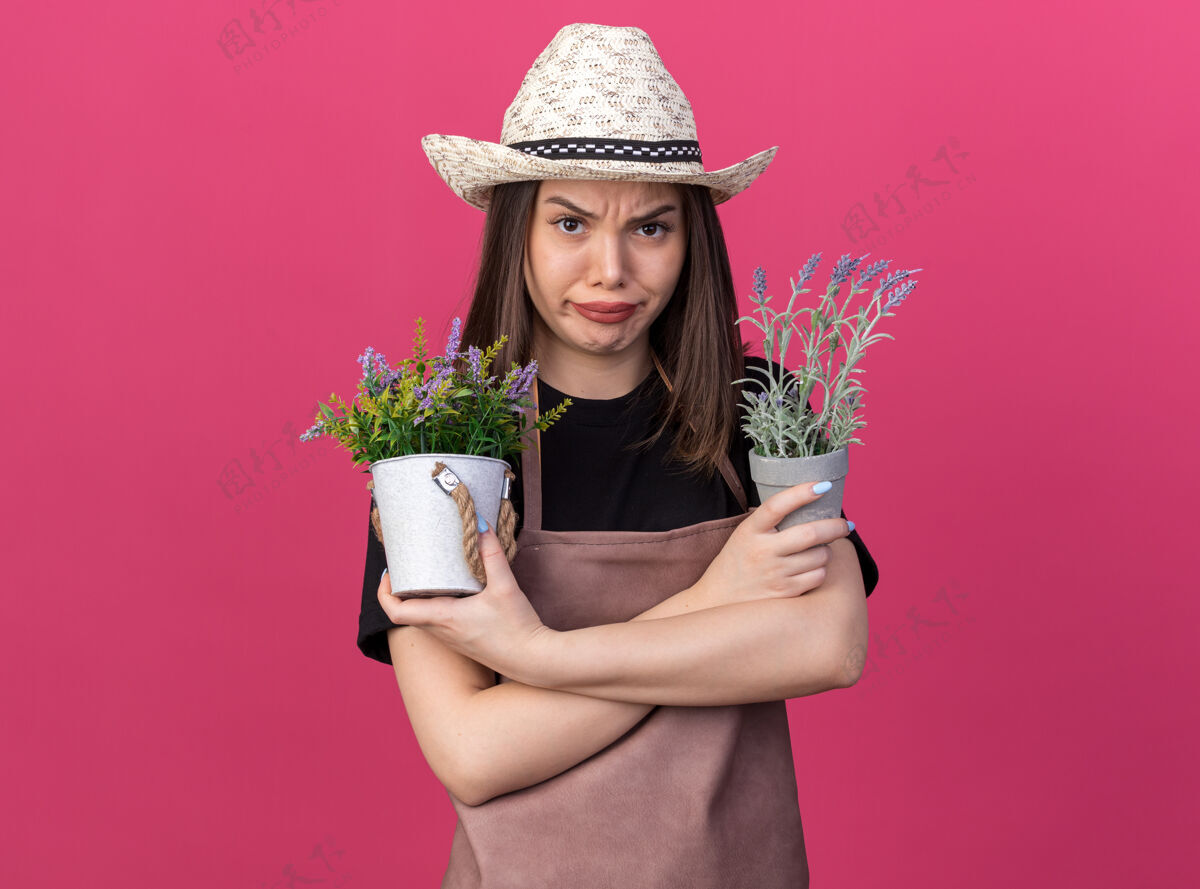 穿愤怒美丽的白人女园丁戴着园艺帽 双臂交叉 手持花盆站着手臂女性